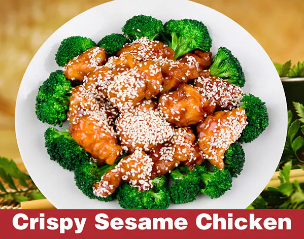 Crispy sesame chicken with broccoli florets on a white plate at Great Wall, a Chinese Restaurant in Indianapolis