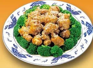 Sesame chicken served over broccoli florets on a blue-and-white plate at Great Wall, a Chinese Restaurant in Indianapolis